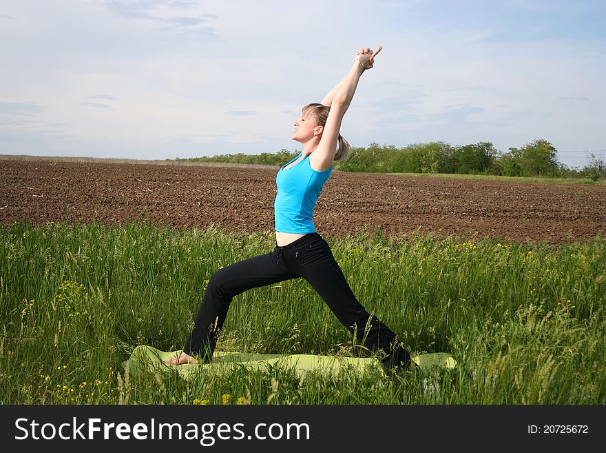 Young woman doing yoga exercises outdoors. Young woman doing yoga exercises outdoors