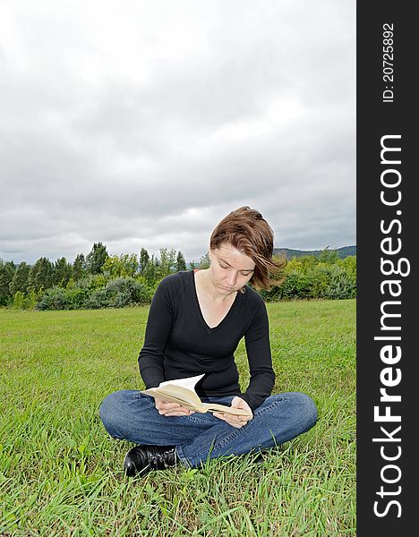 Young woman reading a book on the meadow. Young woman reading a book on the meadow