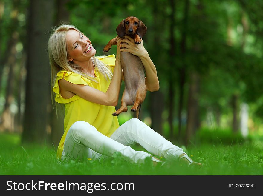 Woman dachshund in her arms on grass