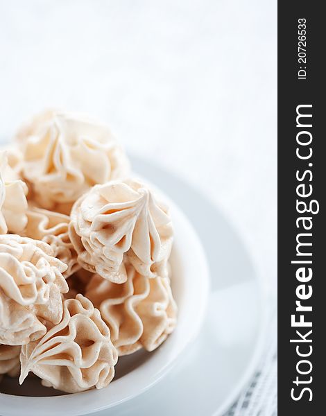 Meringues on white tablecloth, shallow dof.