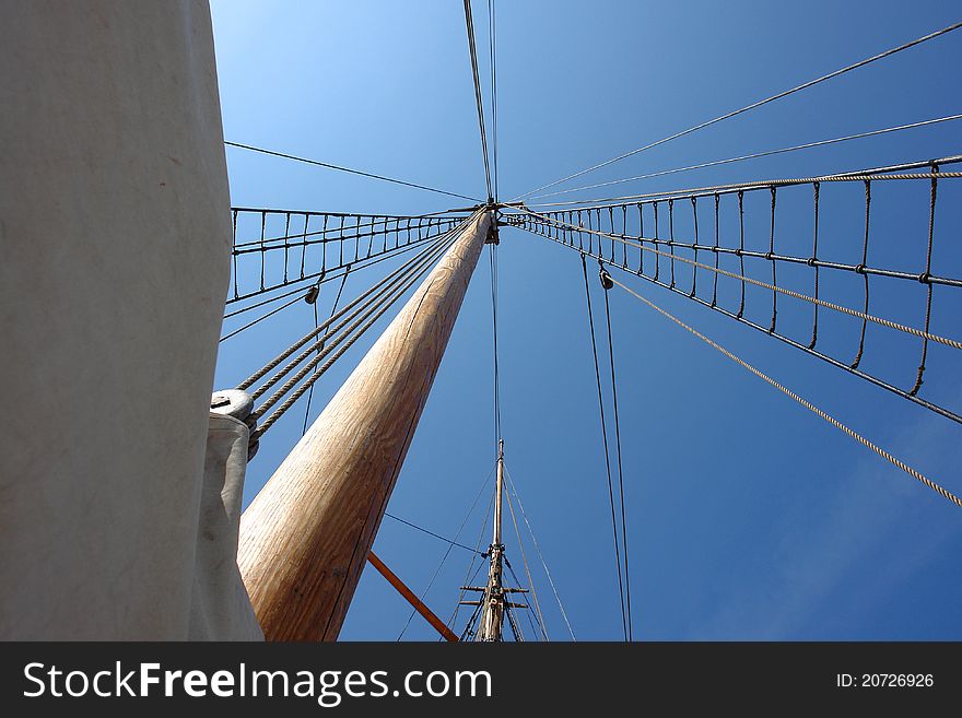 Foresail, Jib, and Wooden Mast of a sailing yacht vertical perspective boating background