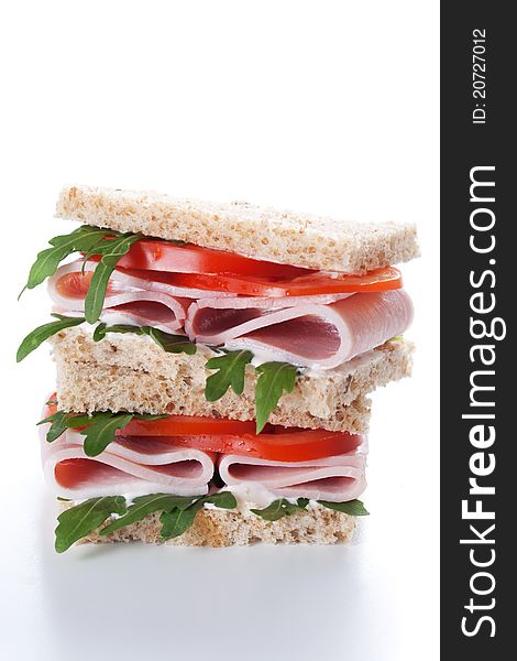 Sandwich with ham,tomato, and rucola salad on white