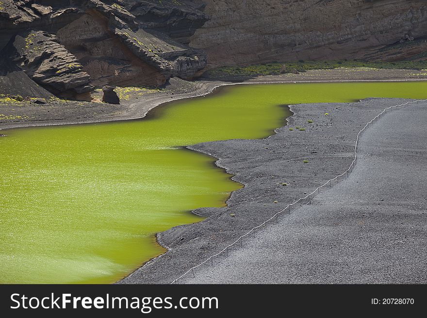 Lago Verde, a half-moon-shaped lagoon of a striking green colour at El Golfo in Lanzarote. Lanzarote , is one of the Canary Islands, in the Atlantic Ocean, appr. 125 km off the coast of Africa. Lago Verde, a half-moon-shaped lagoon of a striking green colour at El Golfo in Lanzarote. Lanzarote , is one of the Canary Islands, in the Atlantic Ocean, appr. 125 km off the coast of Africa.