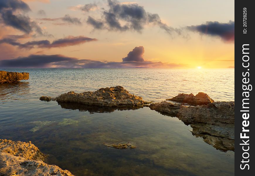 Sea and rock at the sunset. Nature composition.