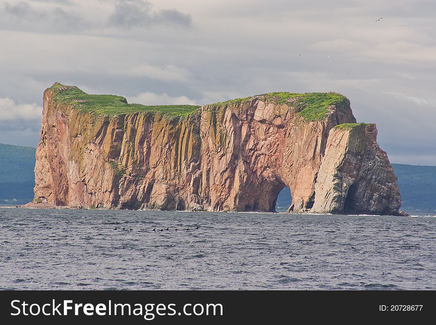 Perce Rock lit by afternoon light in Gaspe, Canada.