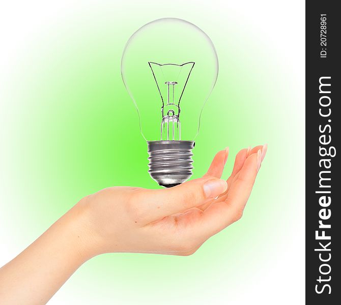 Bulb in a hand on a green background