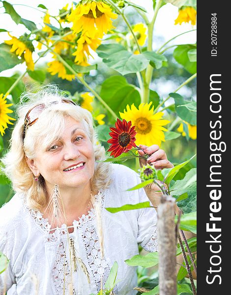 Happy Woman With Flowers In Her Garden