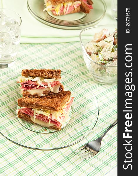 Traditional reuben sandwich cut into quarters served with potato salad