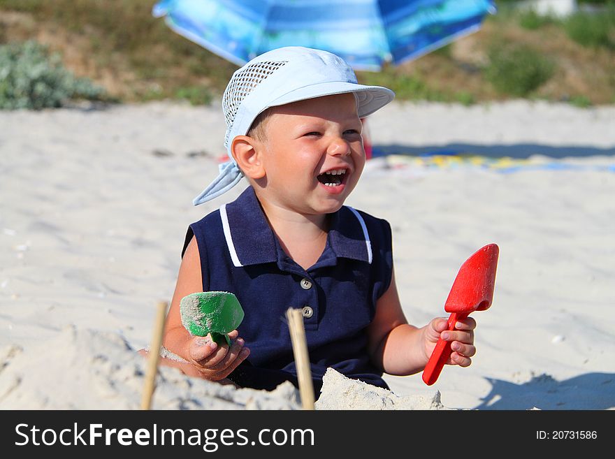 The kid at the beach playing with sand