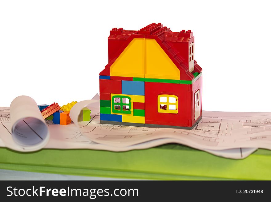 Toy house near drawings and blocks