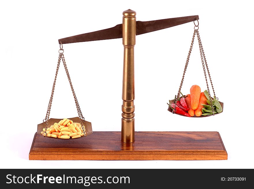 Tablets and fresh vegetables on a brass scale. Tablets and fresh vegetables on a brass scale