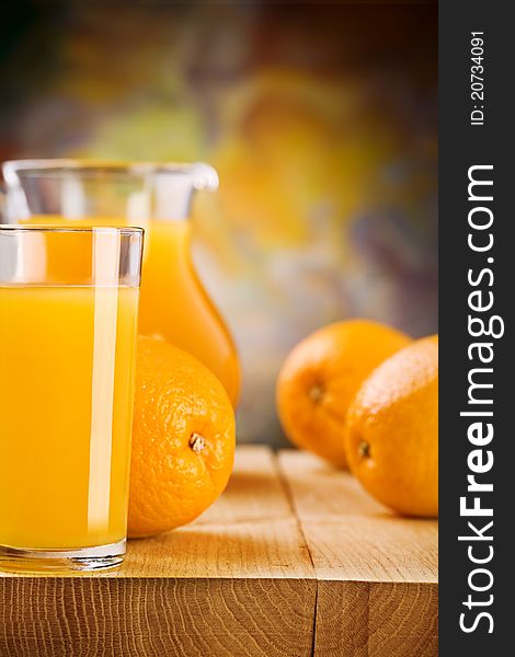 Studio shot 
glass with juice and oranges on wooden boards