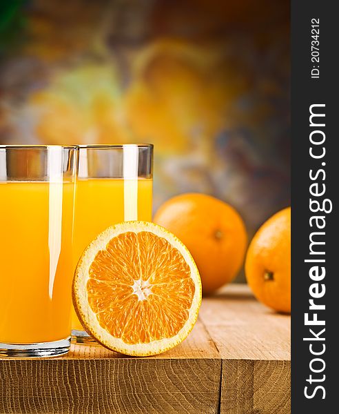 Oranges and juice of oranges in glass and jug On wooden boards.