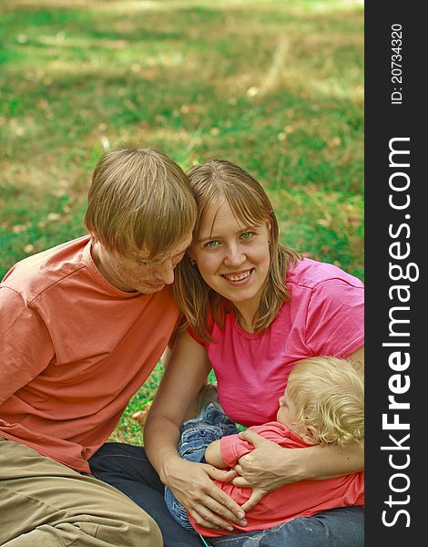 Young couple with sleeping baby enjoying being together in summer nature. Young couple with sleeping baby enjoying being together in summer nature