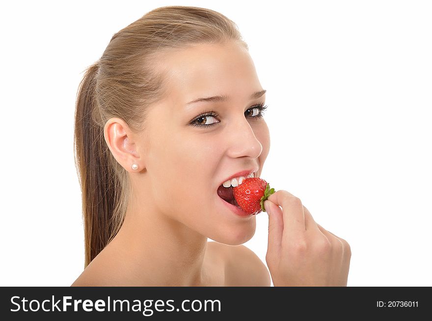 Young woman with ponytail biting into a red strawberry. Young woman with ponytail biting into a red strawberry