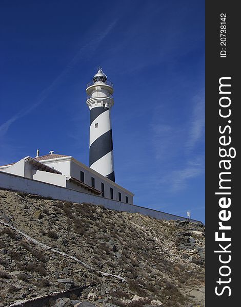 View of Favaritx lighthouse against bright blue sky. View of Favaritx lighthouse against bright blue sky