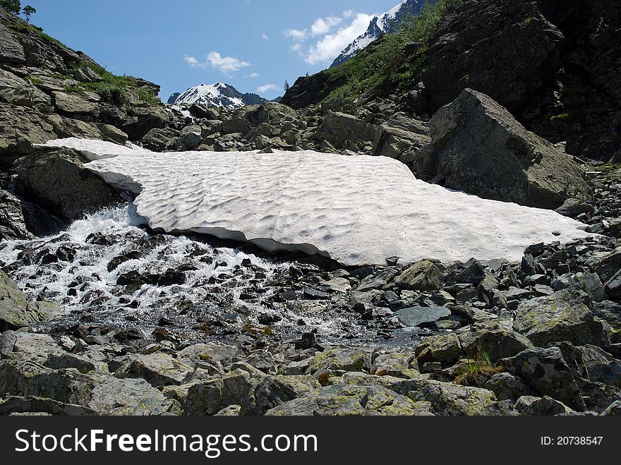 Mountain stream and melting snow high up in the mountains. Mountain stream and melting snow high up in the mountains