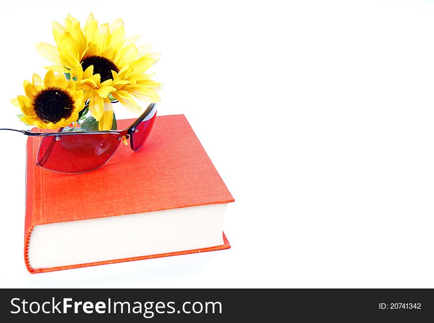 Book and sunglases with a sunflower