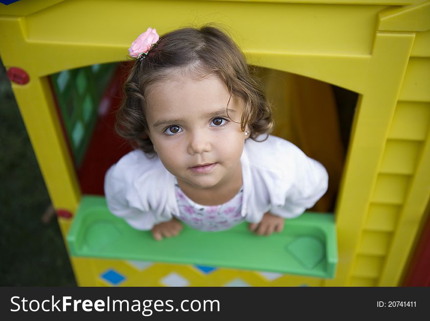 Beautiful little girl playing inside a toy house. Beautiful little girl playing inside a toy house