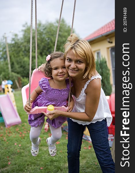 Mom Pushing Daughter on Swing. Mom Pushing Daughter on Swing