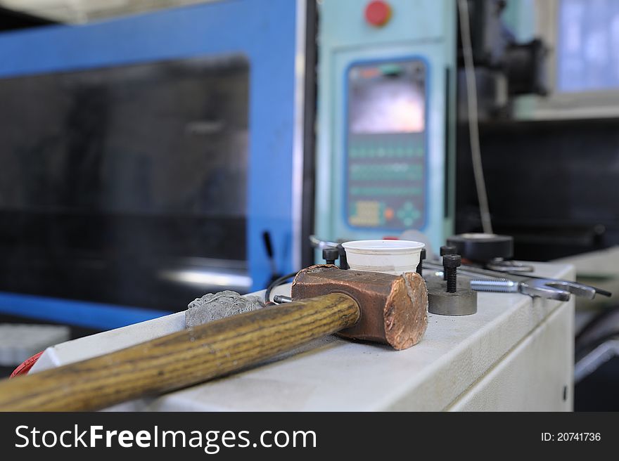 Working tools with a hammer and pliers and kitchen utensils in the background leaning on shelves. Working tools with a hammer and pliers and kitchen utensils in the background leaning on shelves