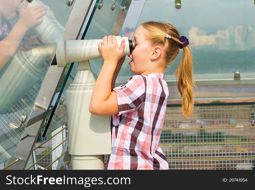 Young girl looking through tourist telescope , exploring landscape. Young girl looking through tourist telescope , exploring landscape.