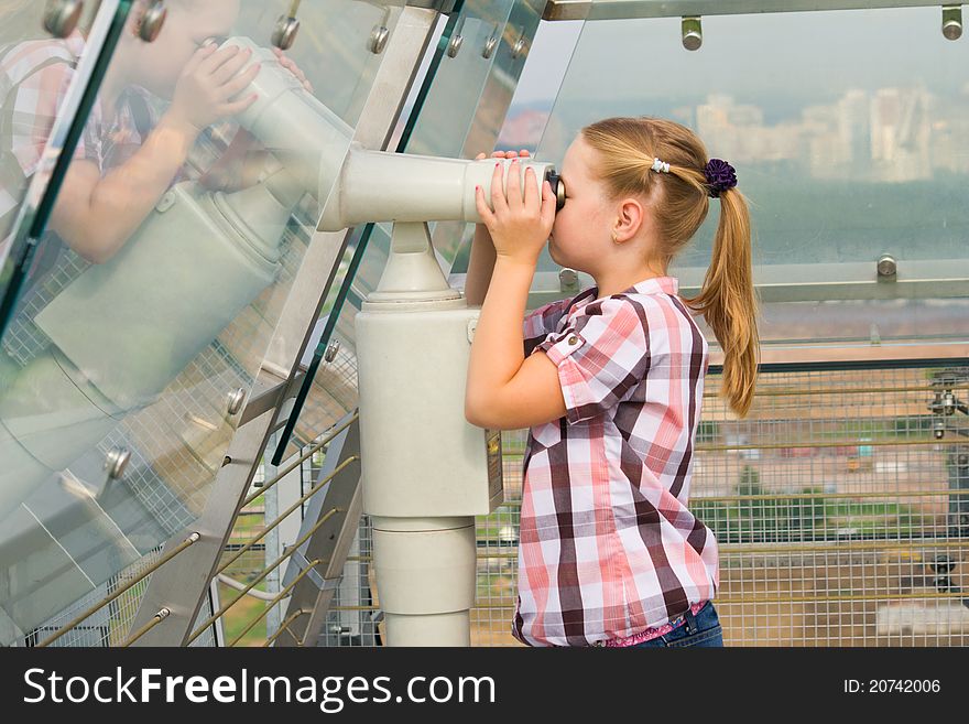 Young girl looking through tourist telescope , exploring landscape. Young girl looking through tourist telescope , exploring landscape.