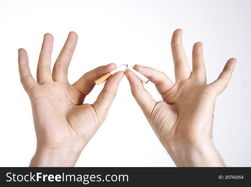 Adult man's hands breaking a cigarette