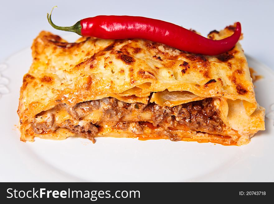 Slice of lasagne with chilli pepper