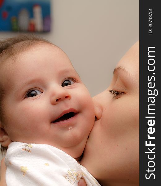 Young mother kissing a newborn son, little baby boy, beautiful and happy face, love and happiness