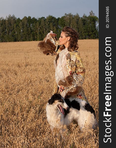 Woman in clothes of 18 centuries outdoors hold borzoi dog. Woman in clothes of 18 centuries outdoors hold borzoi dog