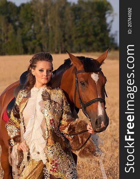 The young woman in clothes of 18 centuries with horse outdoors. The young woman in clothes of 18 centuries with horse outdoors