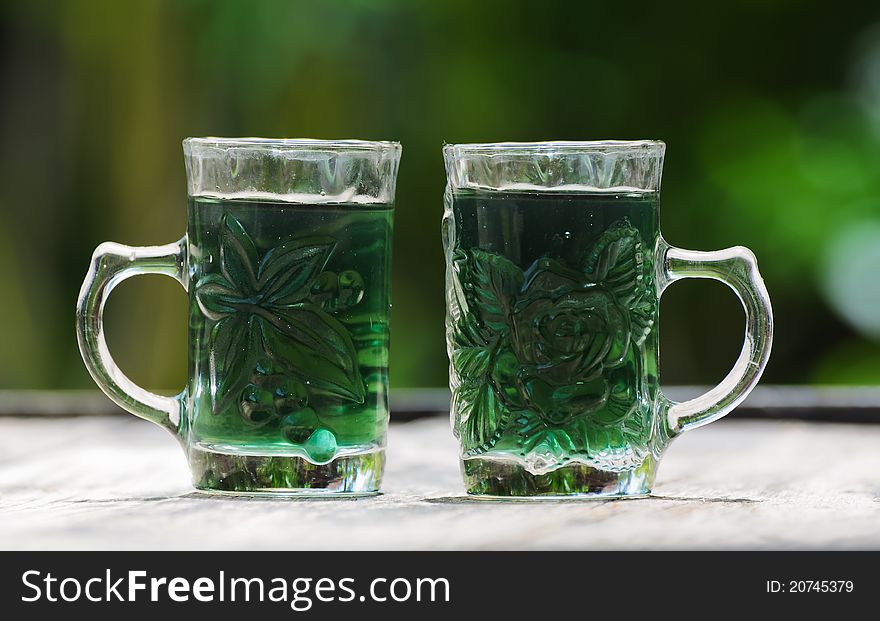 Image of glass with green water and green background
