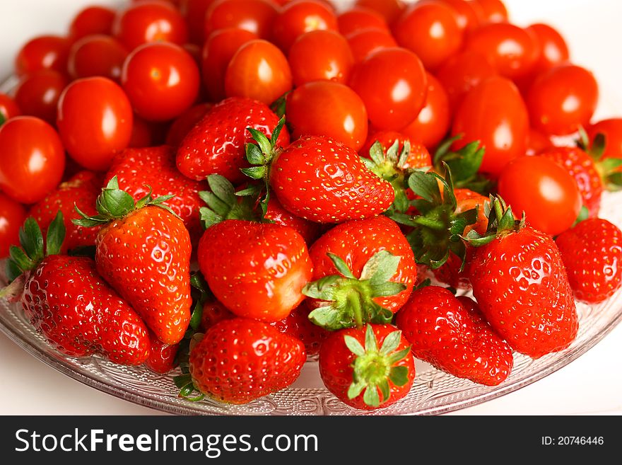 Many red strawberry and tomato in dish