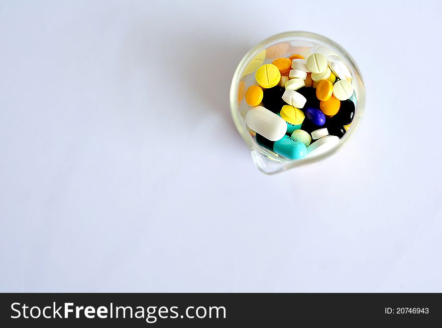 Variety of pills in beaker