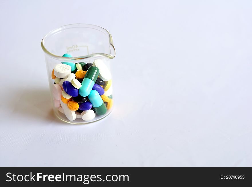 Variety of pills in a beaker