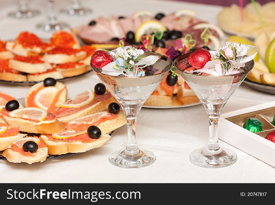 Close up of a festive table with sweets, sandwiches and wine glasses. Close up of a festive table with sweets, sandwiches and wine glasses