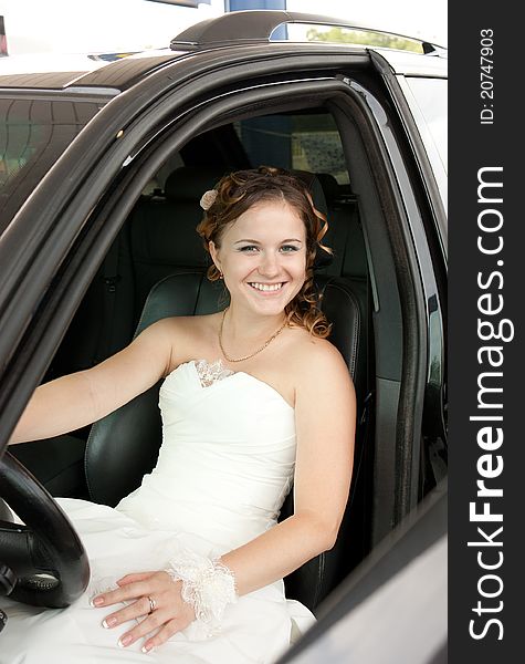 Woman in a wedding white dress in the car. Woman in a wedding white dress in the car
