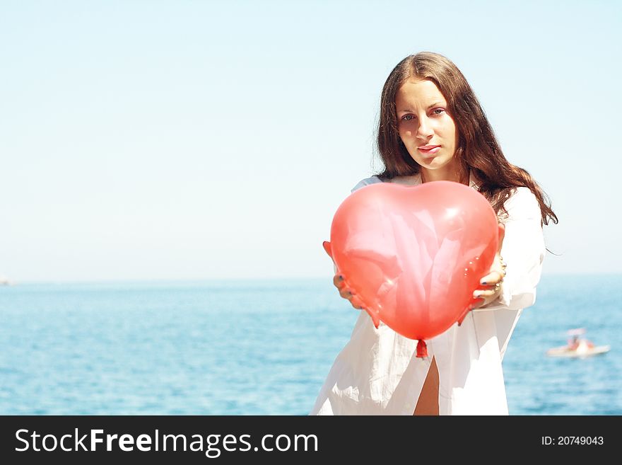 Girl Keeps Air Ball In Form Heart Near Sea