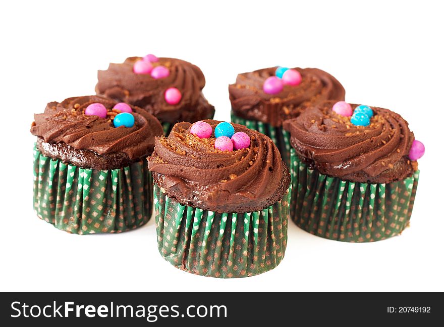 Miniature decorated chocolate cupcakes on white background. Miniature decorated chocolate cupcakes on white background