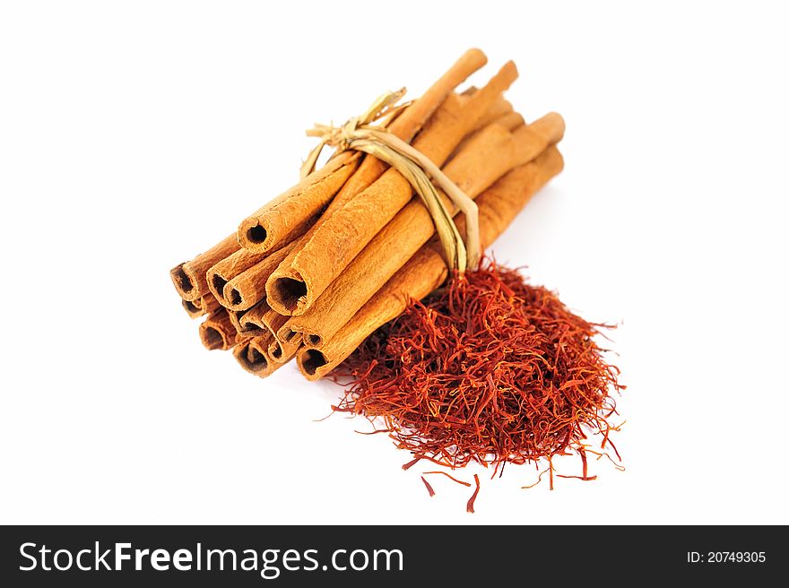 Sheaf of cinnamon and saffron on the white background. Sheaf of cinnamon and saffron on the white background