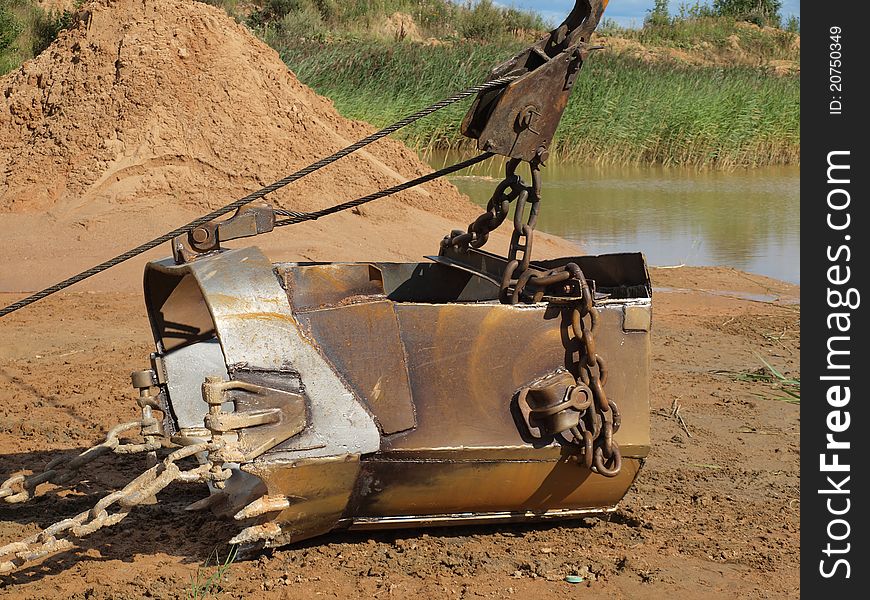 Spade of old excavator  in a sand quarry. Spade of old excavator  in a sand quarry.