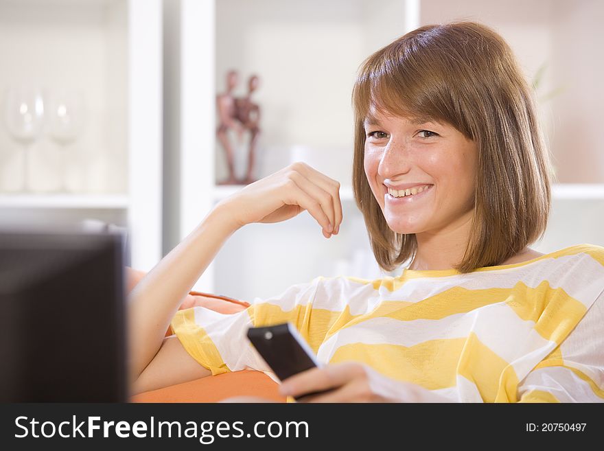 Woman smiling while watching television at home