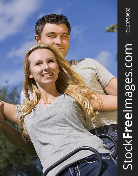 Happy young couple on a swing outdoor