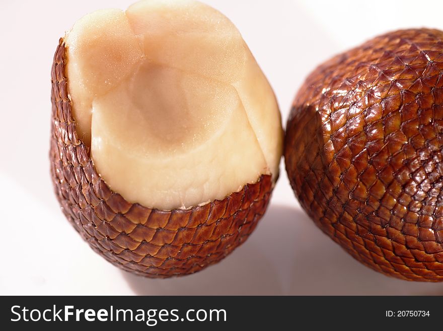 These are salak fruits. the skin is scaly-reddish brown. very well netting skin structures. by pinching the tip, it can be pulled away. the fruit inside consists of three fleshy lobes, each contains a large inedible seed. the taste is usually crunchy and sweet-sour.