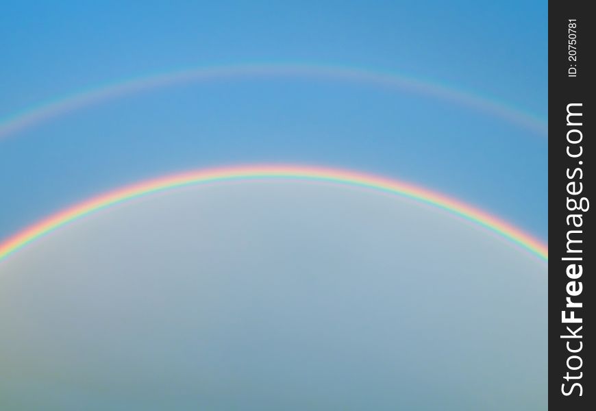 Detail of a rainbow on the blue sky in summer time. Detail of a rainbow on the blue sky in summer time