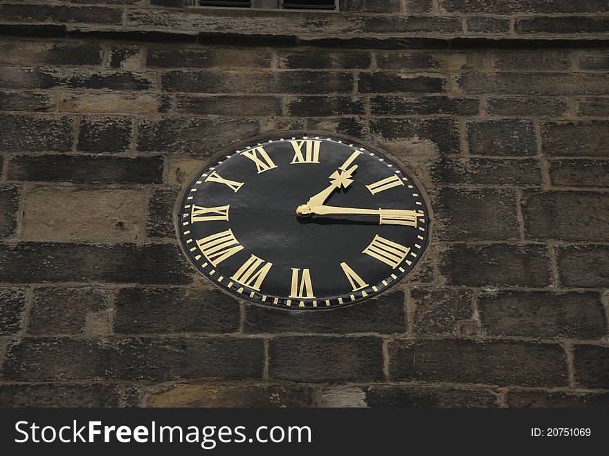 A Vintage Black and Gold Clock on a Church Tower