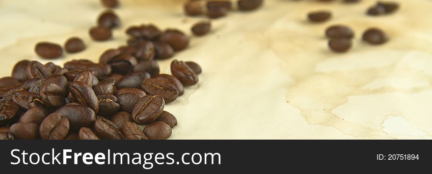 Freshly Roasted Coffee Beans on a Texture of Stained Paper