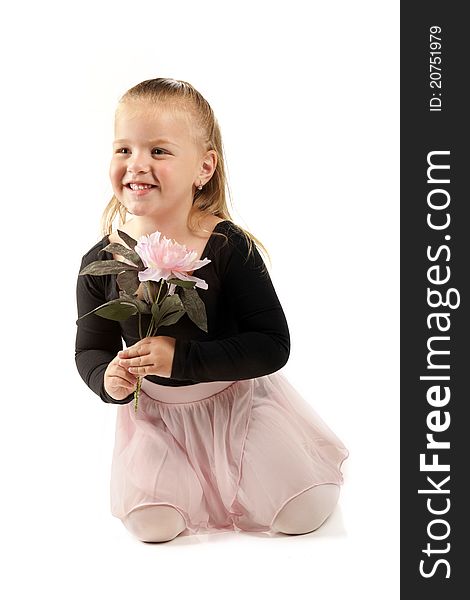 A pretty preschool ballerina holding a large, pink flower. on white.