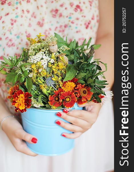 Girl with flowers in a bucket